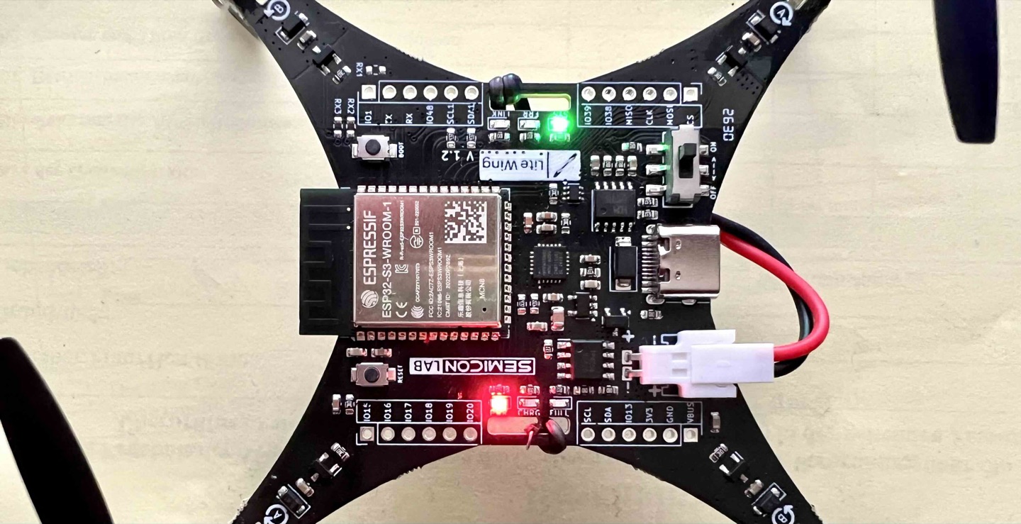 A small flight-controller board with an ESP32-S3 module, its battery, and a USB bridge.
